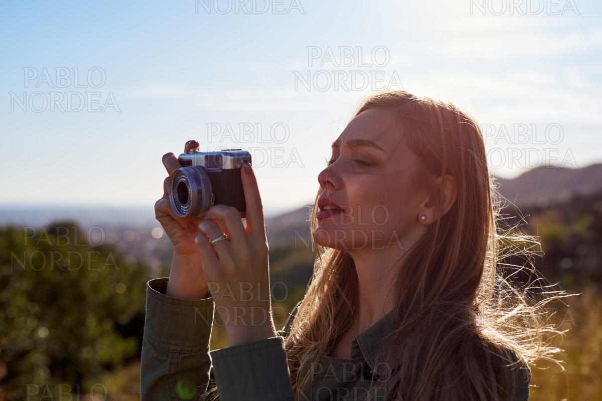 Adult woman photographing mountains in sunset stock photo