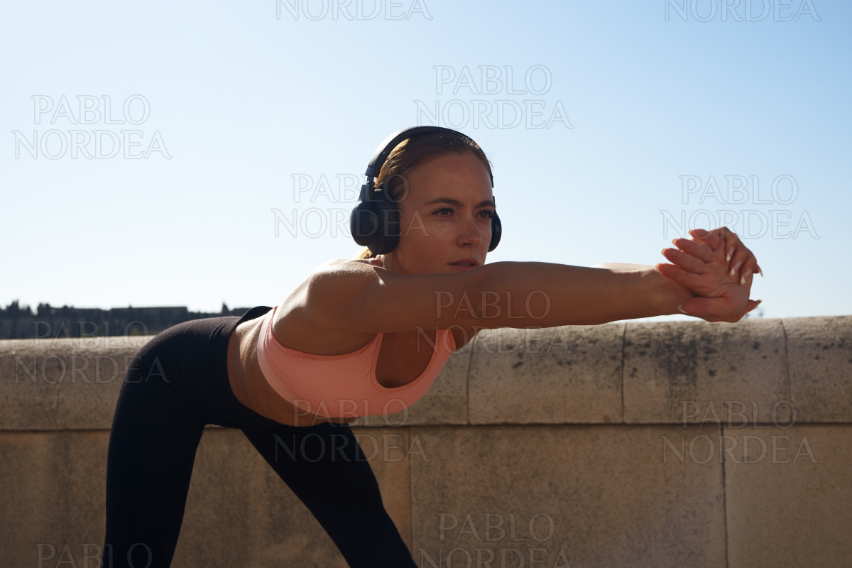 Beautiful fit woman stretching in sun stock photo