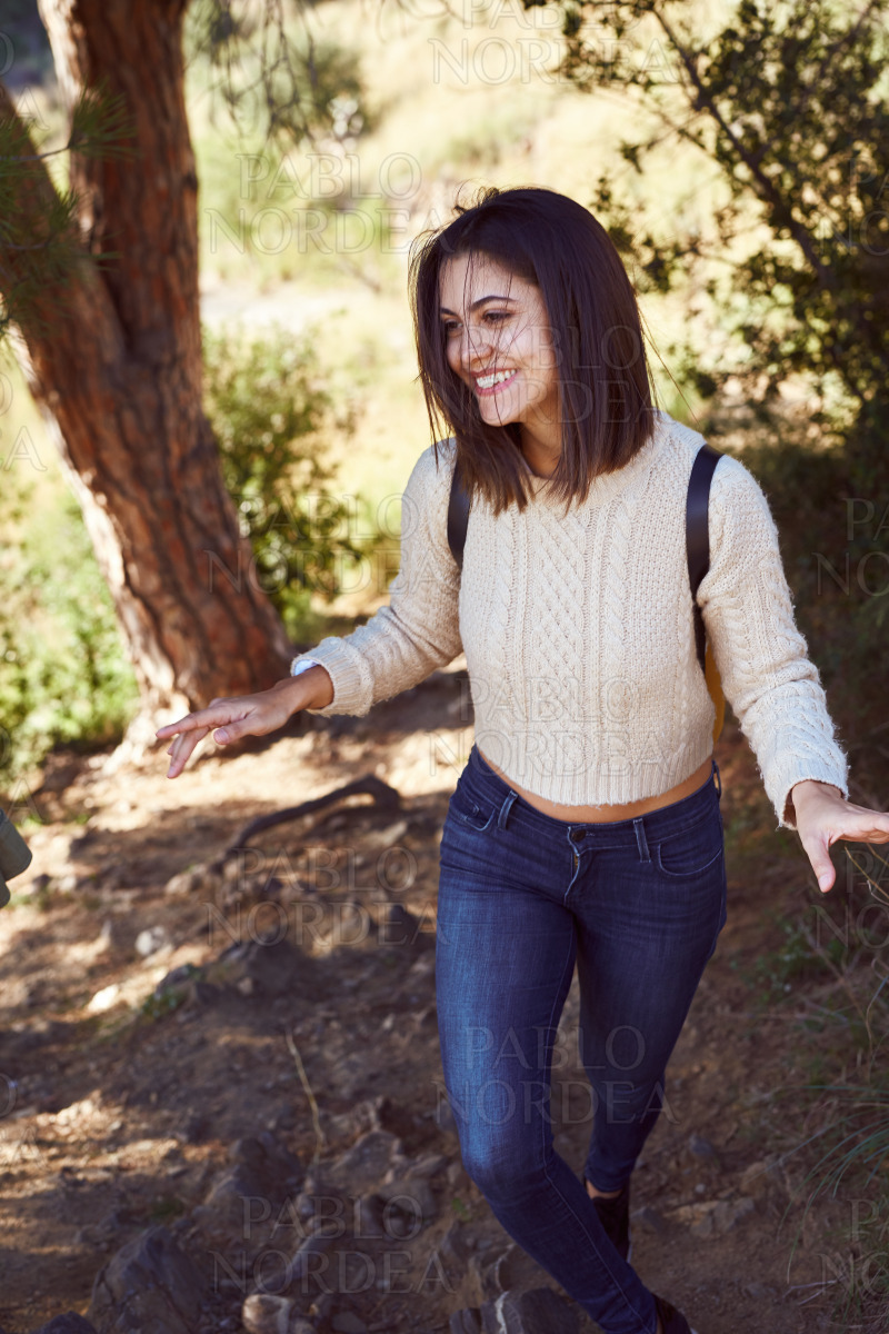 Cheerful young woman going hiking in the woods stock photo