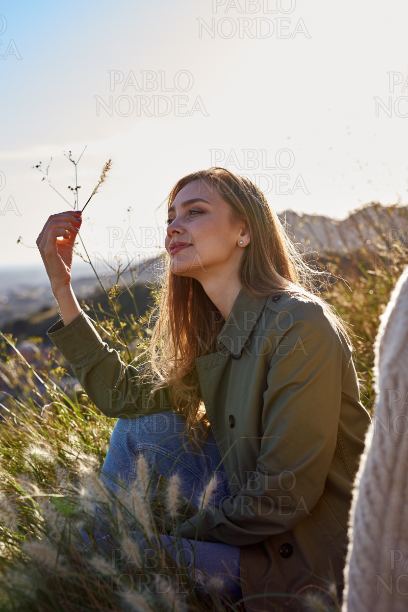 Enthralled lady casually sitting in the grass stock photo