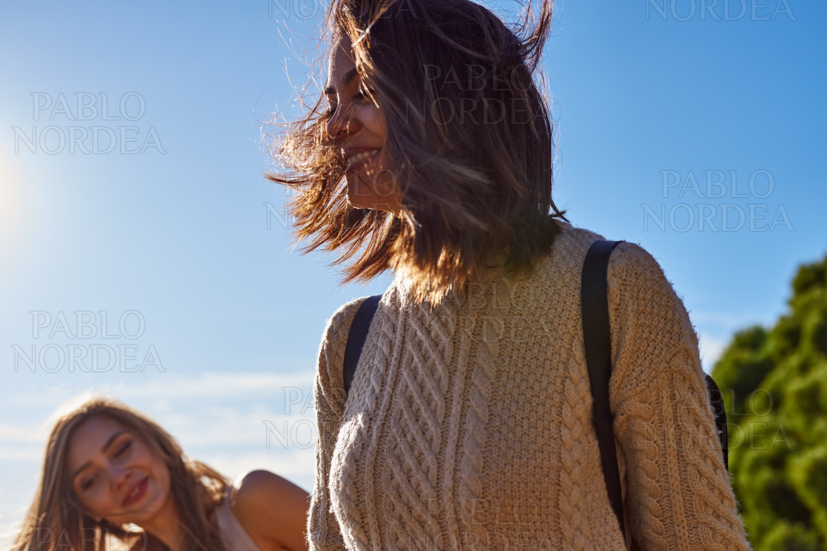 Playful female friends smiling cheerfully outdoors stock photo