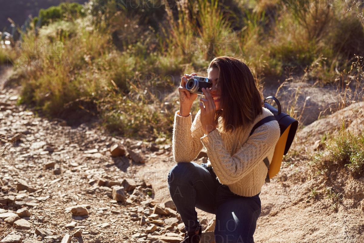 Smiling woman photographing views in mountains stock photo