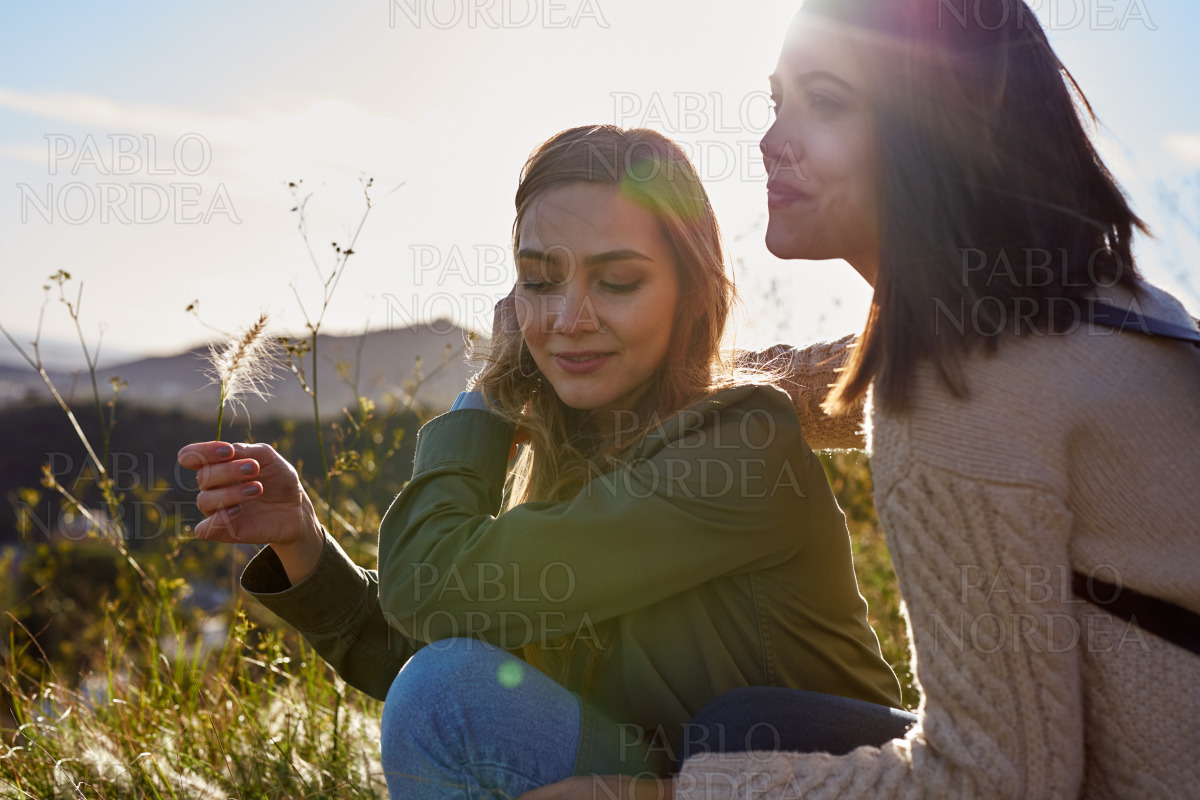Two airy young ladies relaxing in the grass stock photo