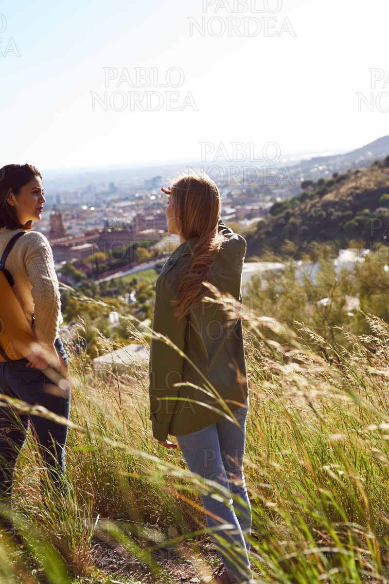 Two best friends standing on a hilltop outdoors stock photo