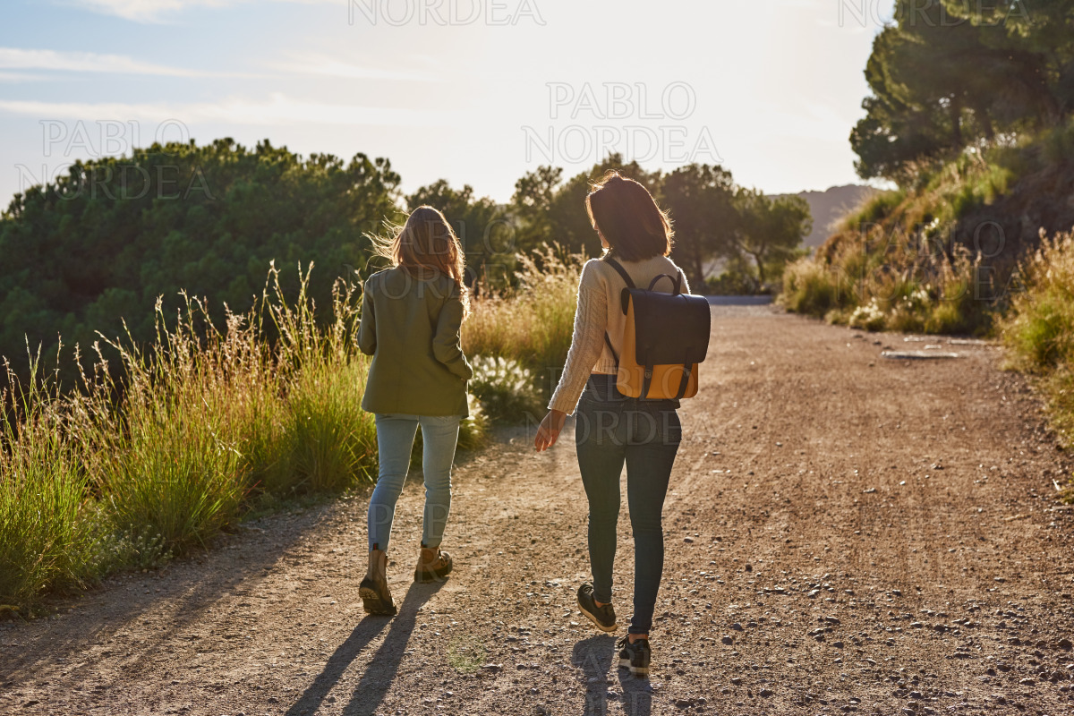 Two energetic ladies strolling along a gravel road stock photo