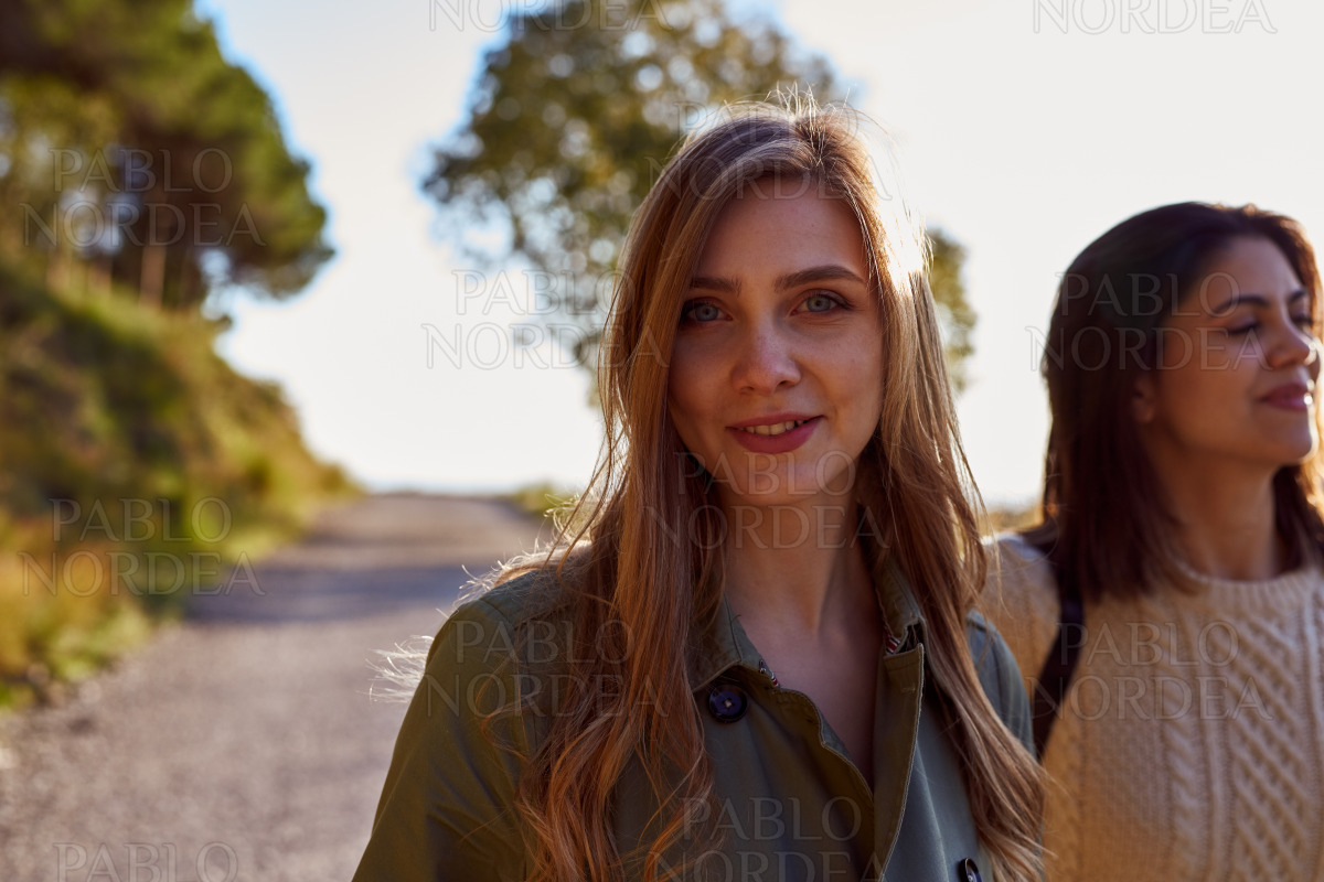 Two female friends on mountain road stock photo
