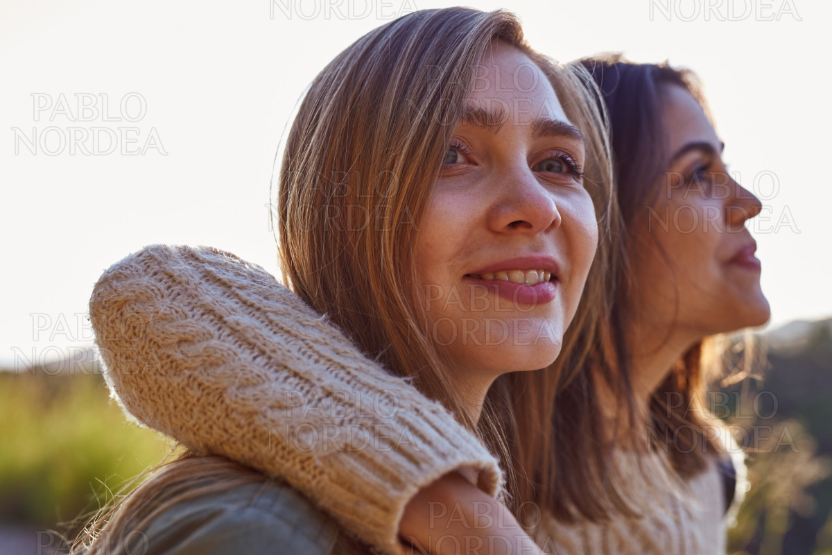 Two female friends standing in mountains stock photo
