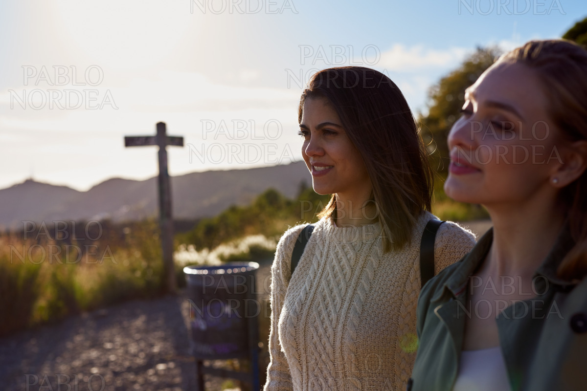 Two intrigued ladies enjoying the view on a hill stock photo
