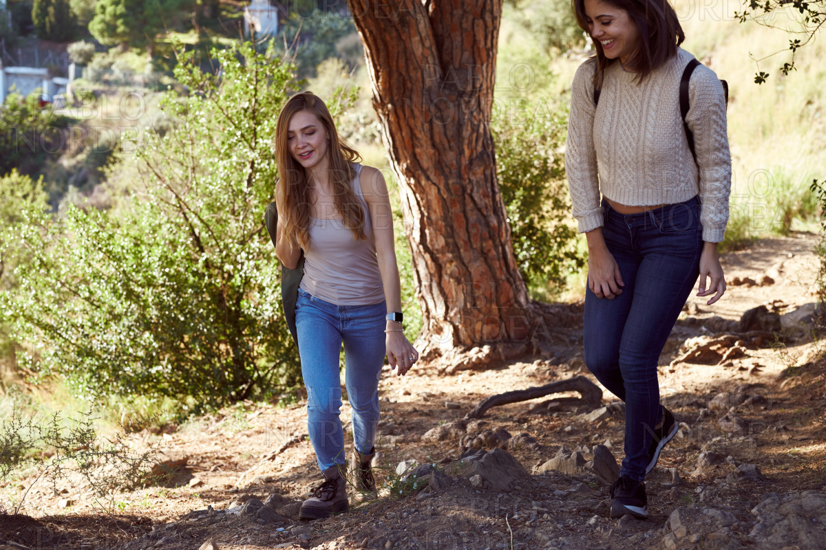 Two young women going hiking in the woods stock photo