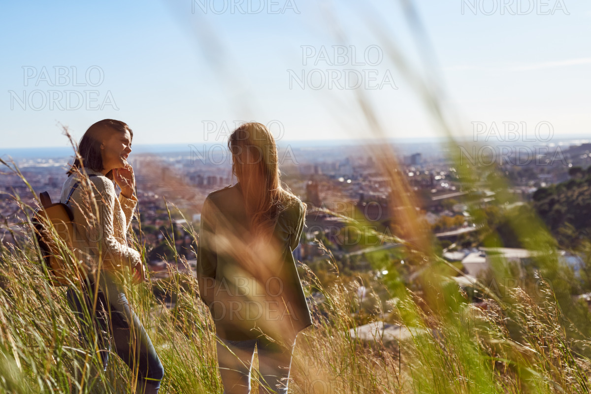 Two young women having a chat on a hilltop stock photo