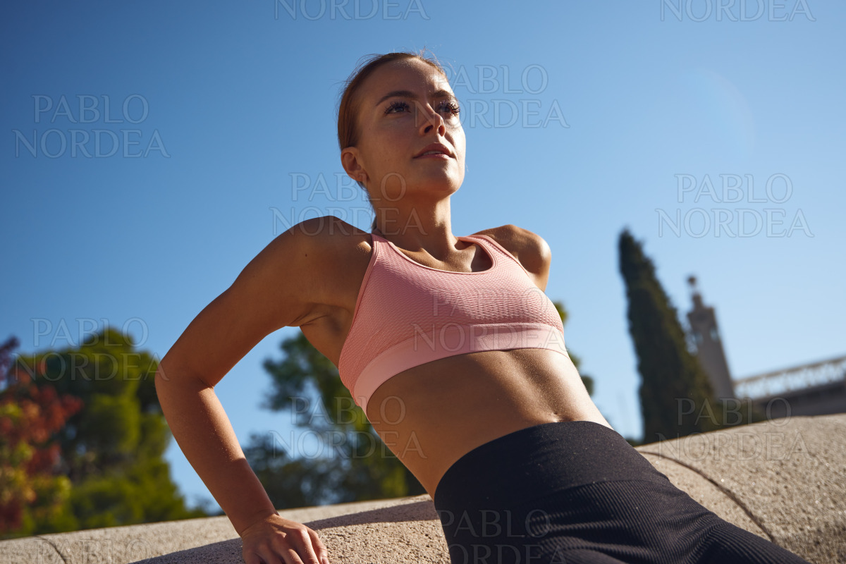 Woman exercising in park on sunny day stock photo