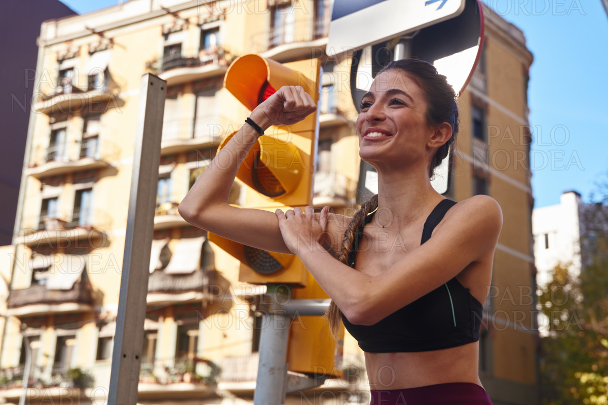 Woman flexes her arm muscles and smiles stock photo