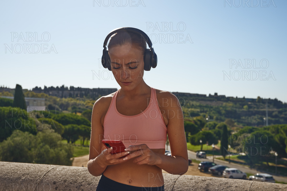 Woman listening to music and text messaging stock photo