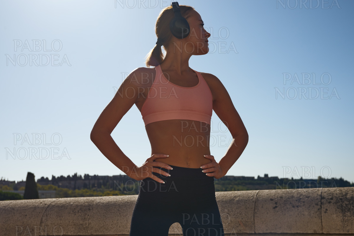 Woman listening to music with hands on hip stock photo