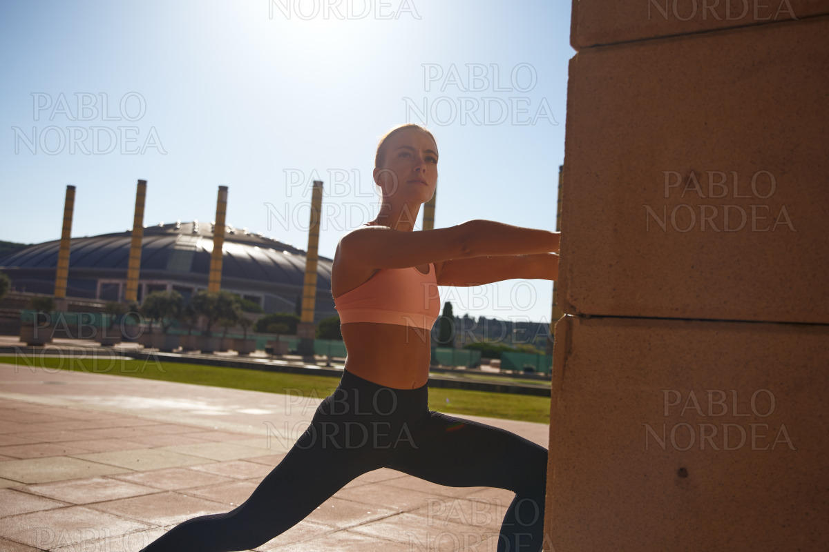 Woman standing and exercising in park in sun stock photo