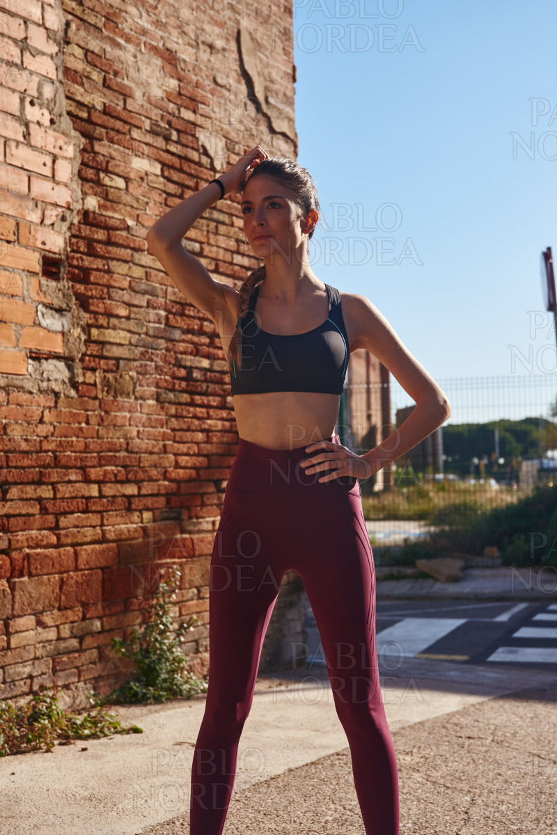 Woman stands stretches as she prepares to exercise stock photo