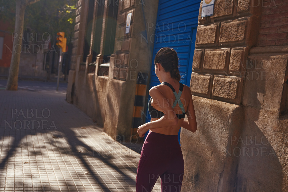 Young woman jogging along a city street stock photo