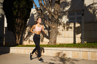 Beautiful woman practising jogging in sun