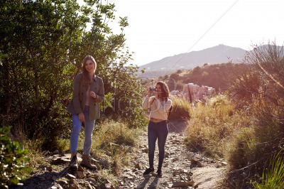 Female friends smiling and standing in mountains