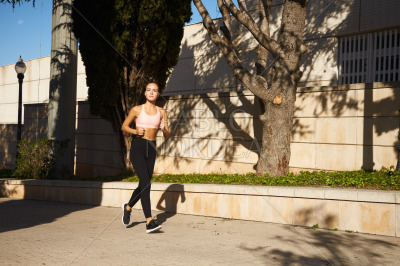 Fit beautiful woman running on street