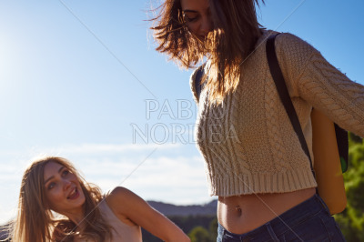 Playful female friends walking together outdoors