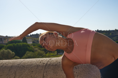 Sporty woman stretching in park on sunny day