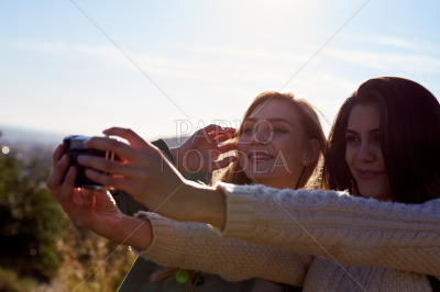 Two female friends taking selfie in mountains