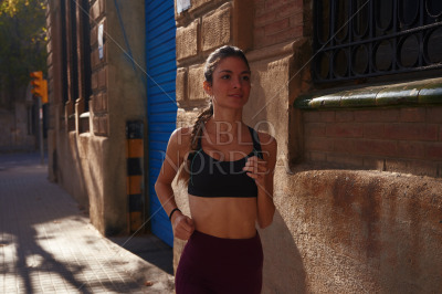 Woman jogging alone on a city street