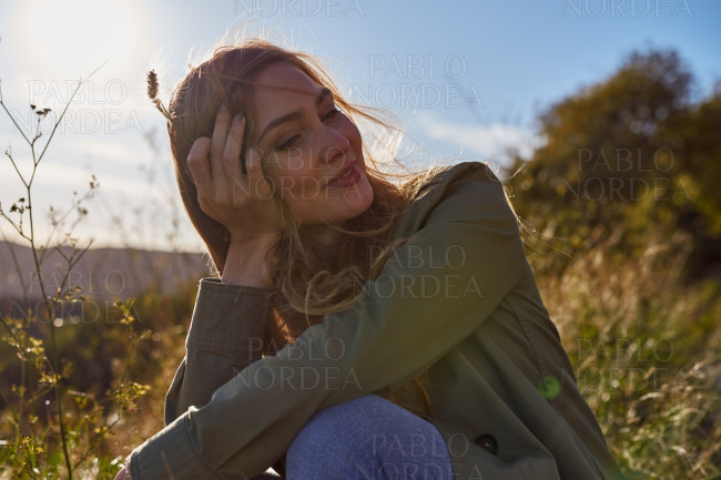 Calm and relaxed lady sitting in a field