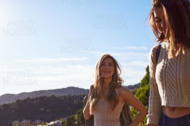 Cheerful female friends going hiking together stock photo