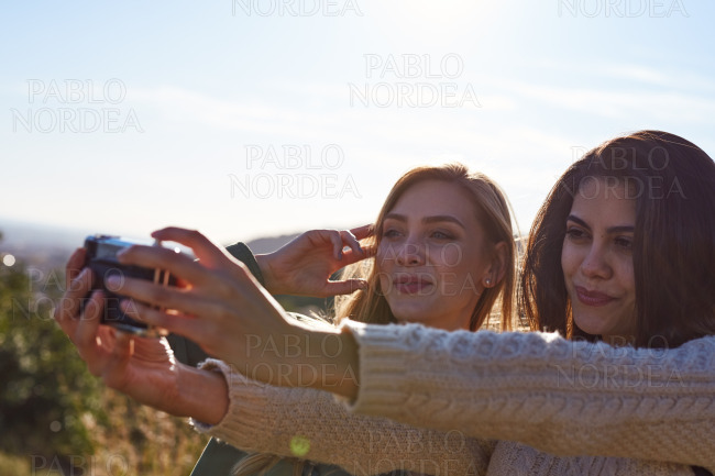 Female friends enjoying selfie on sunny day