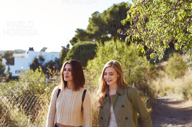Happy female friends walking together outdoors