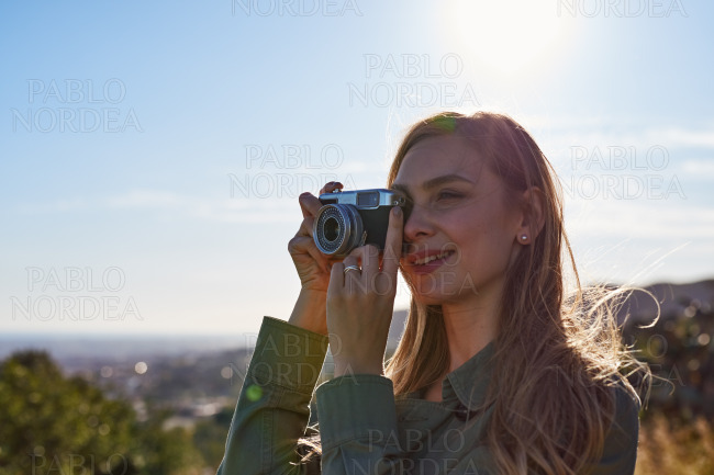 Happy woman taking photos in mountains