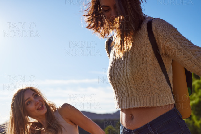Playful female friends walking together outdoors