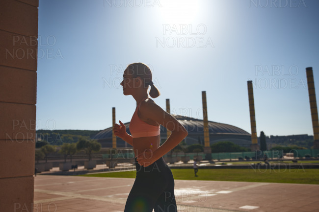 Sporty beautiful woman running on street