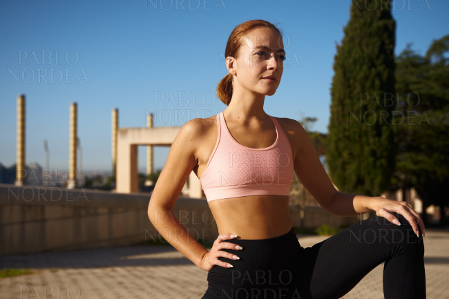 Sporty woman standing and exercising in park