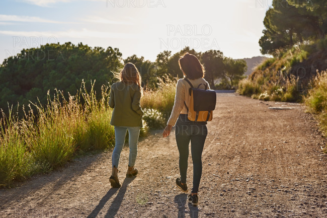 Two energetic ladies strolling along a gravel road