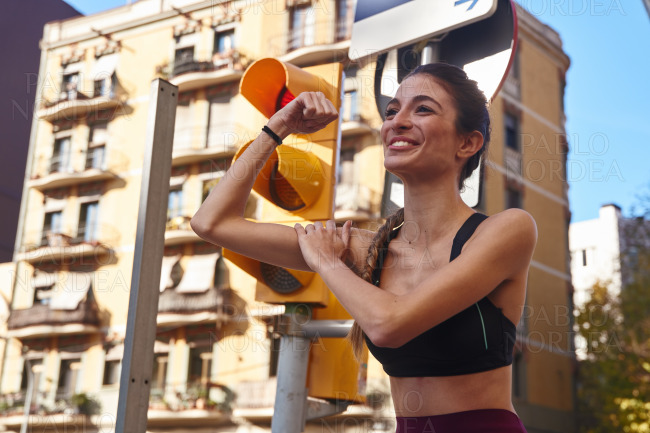 Woman flexes her arm muscles and smiles