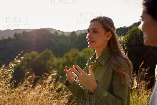 Woman standing on mountain smiling and gesturing