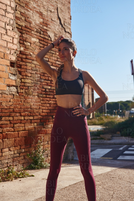 Woman stands stretches as she prepares to exercise