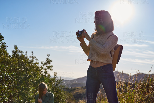 Women in mountains standing and photographing