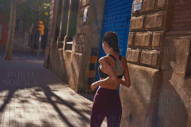 Young woman jogging along a city street