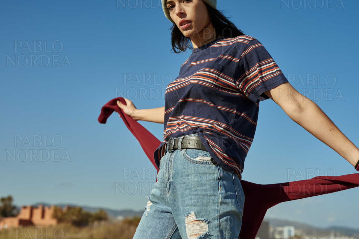 A blase young lady holding on to her sweater stock photo
