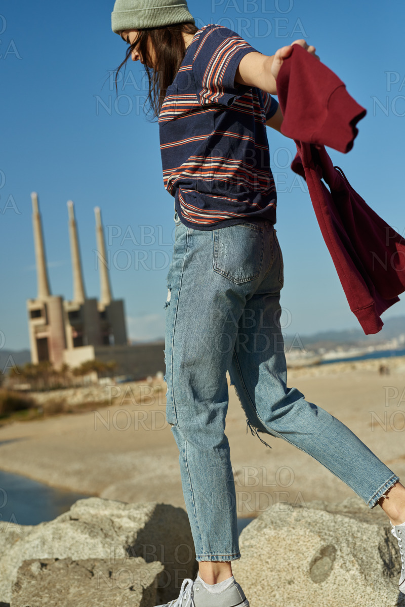 A happy young lady walking on rocks stock photo