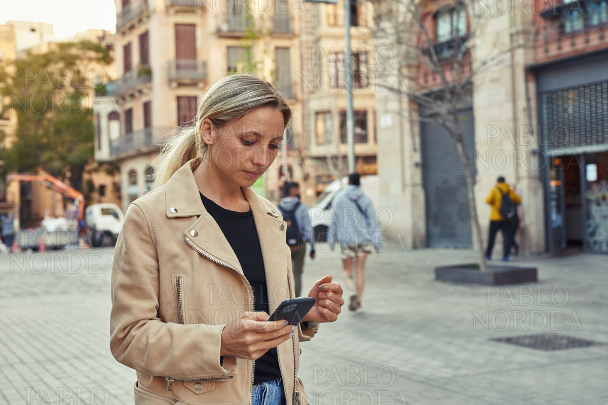 Attractive woman using mobile phone in the city stock photo