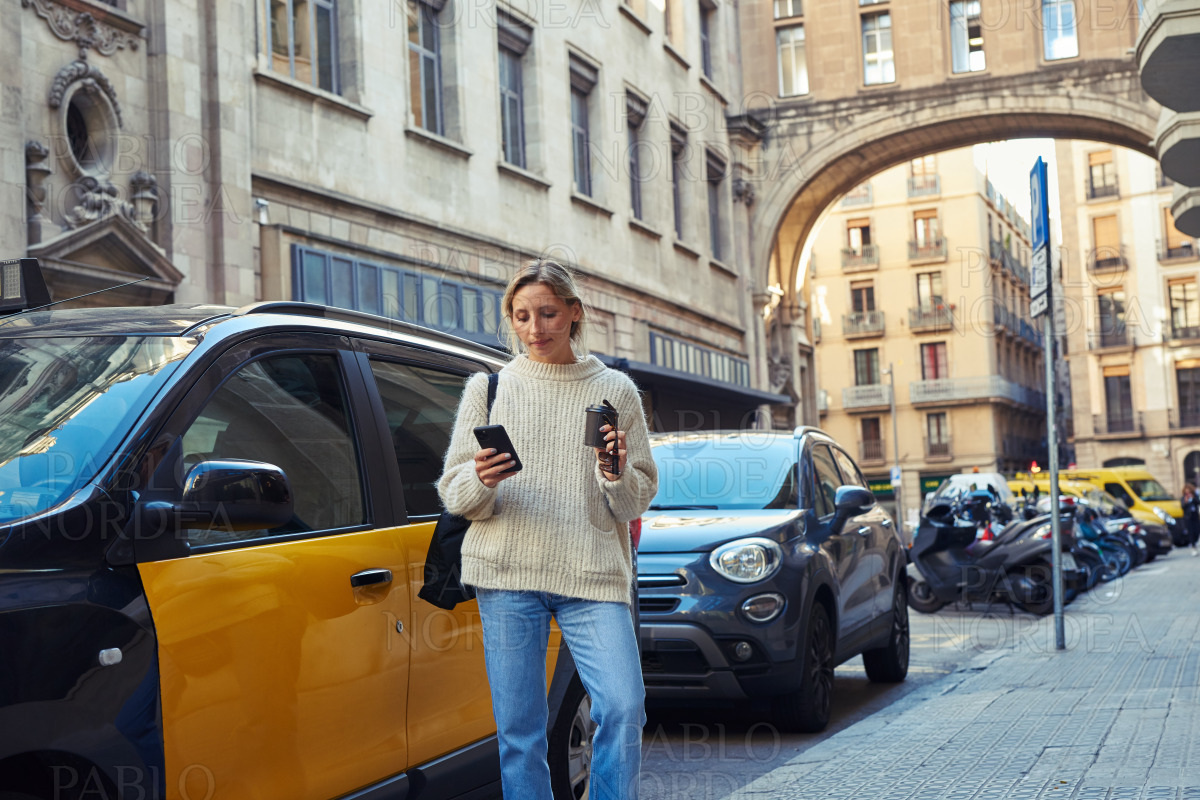 Attractive young woman using phone in the city stock photo