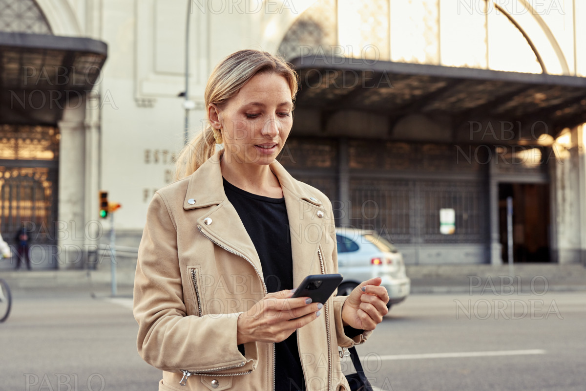 Beautiful woman using mobile phone in the city stock photo