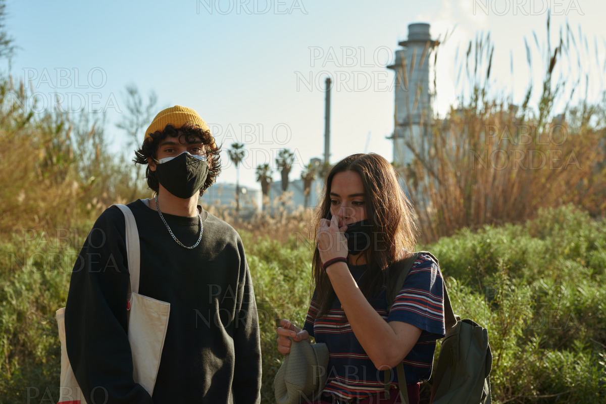 Cute young couple wearing masks outdoors stock photo