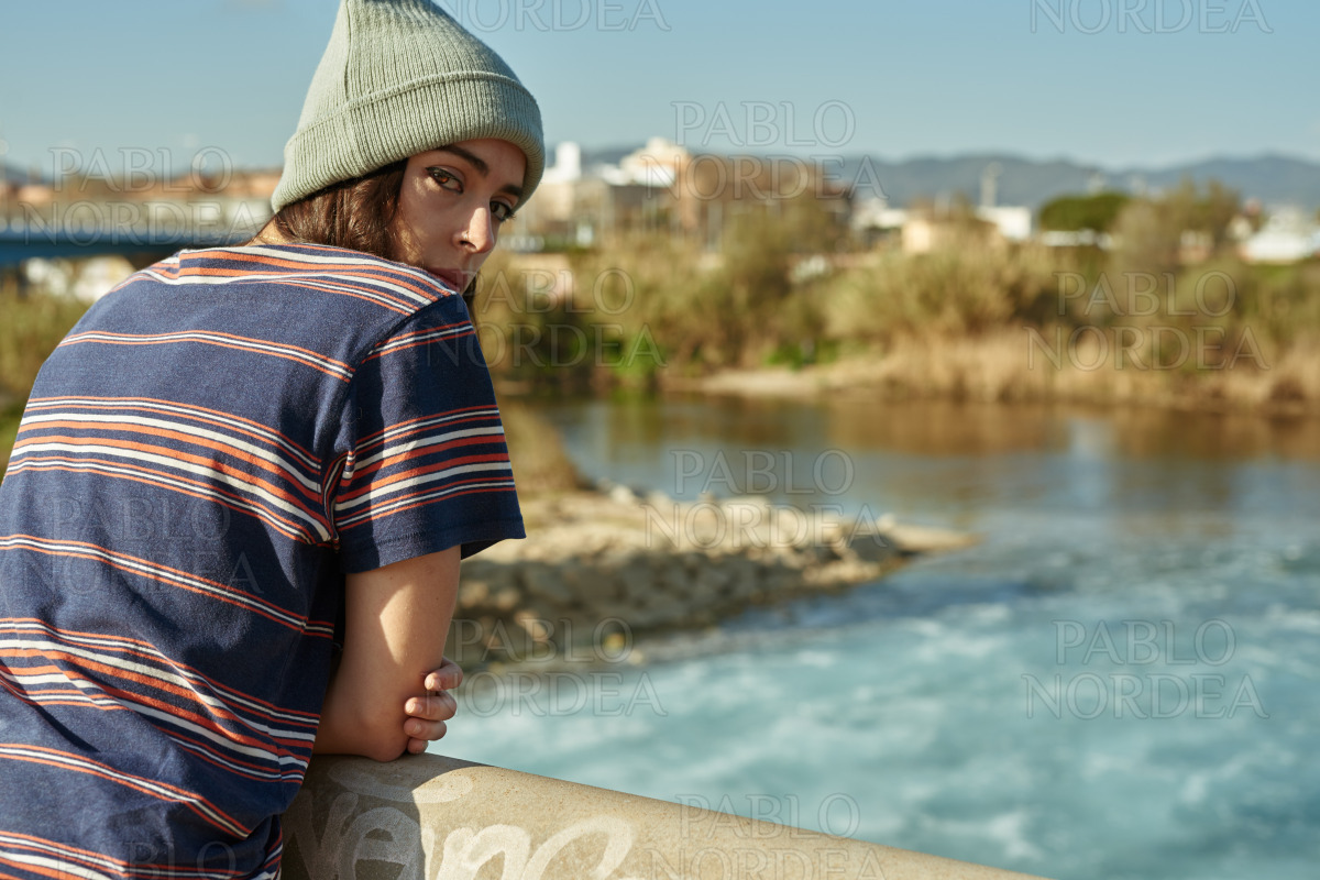 Girl looking at camera on a bridge stock photo