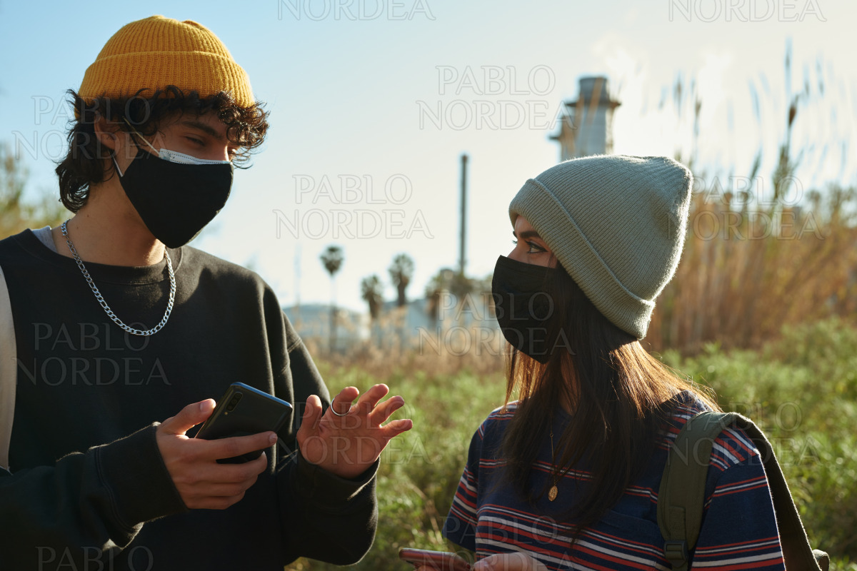 Guy talking to girl while holding cellphone stock photo